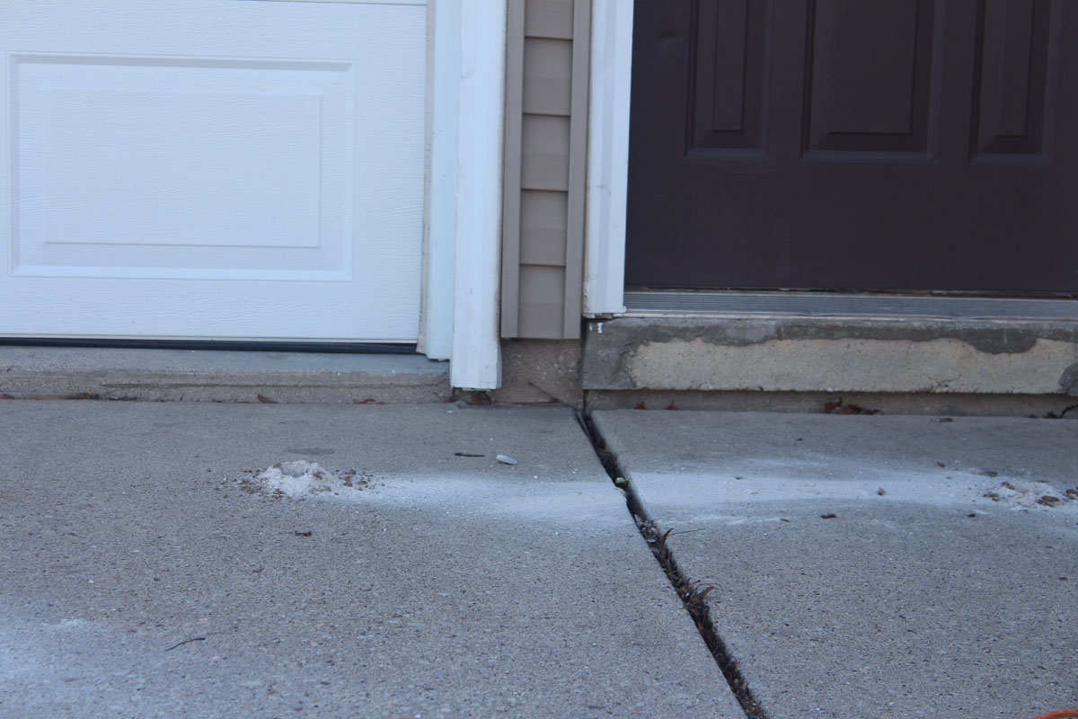 A concrete sidewalk and driveway area at a house foundation